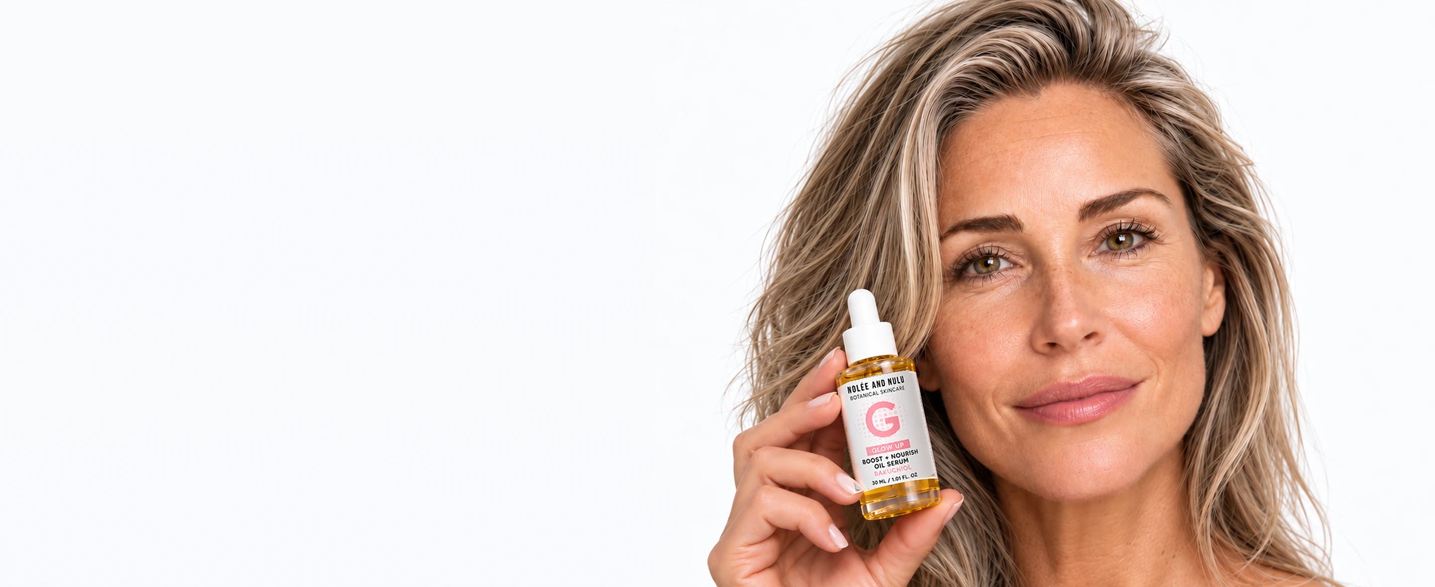 Vrouw met asblond haar houdt de Bakuchiol Oil Serum van Nolée and Nulu naast haar gezicht.